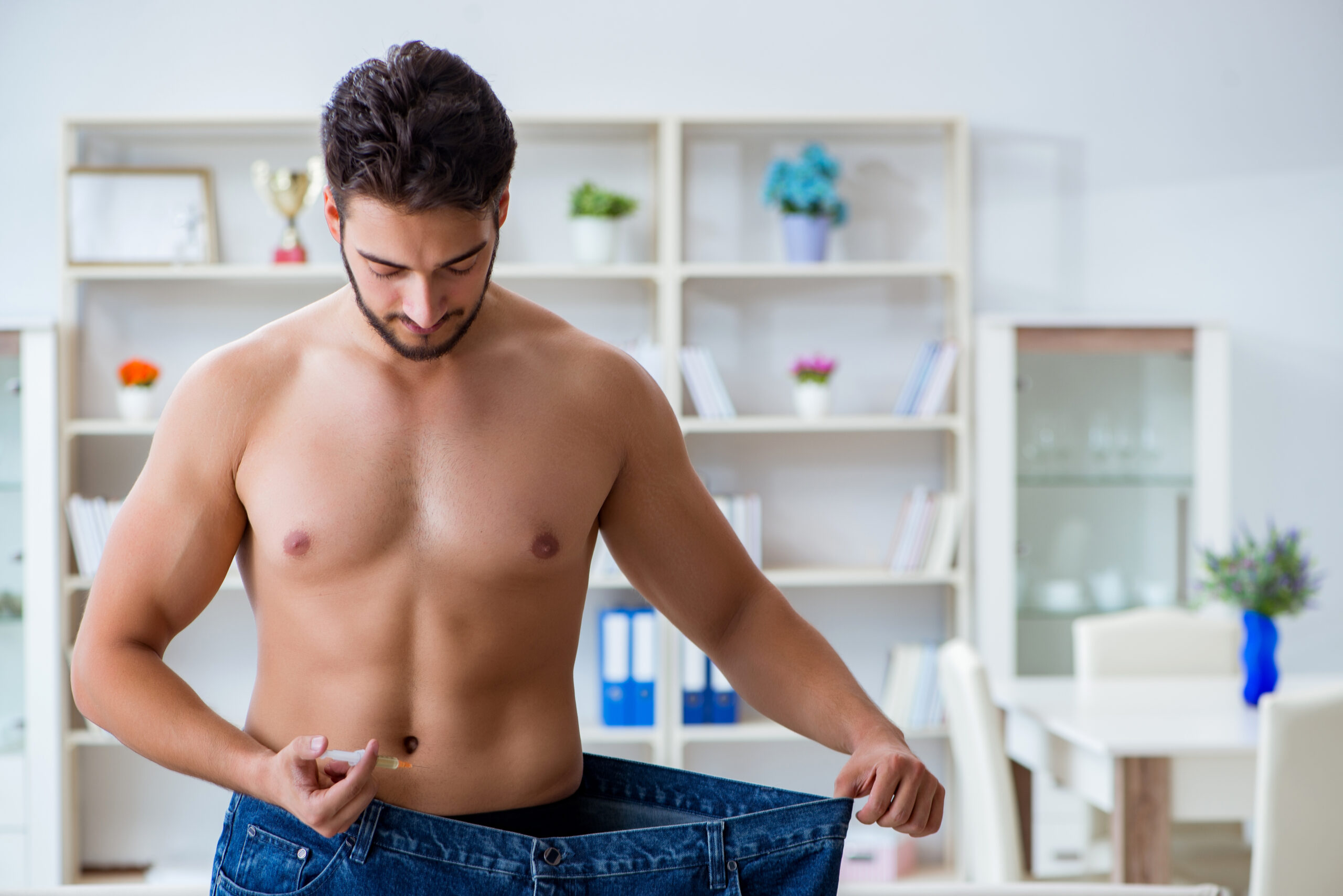 Man in oversized pants showing weight loss - Home