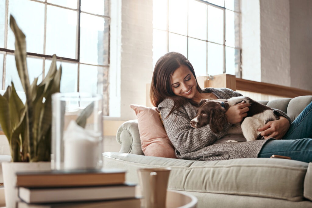 Happy woman relaxing at home with dog representing relief from depression through IV ketamine therapy at Better Health Whole Wellness Center Philadelphia