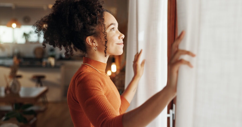Woman looking out window with hope and calm after ketamine therapy for depression and anxiety in Philadelphia