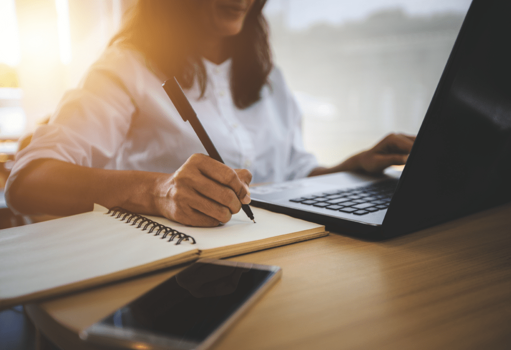Woman writing notes and researching ketamine therapy evidence on laptop representing clinical research behind IV ketamine treatment at Better Health Whole Wellness Center Philadelphia