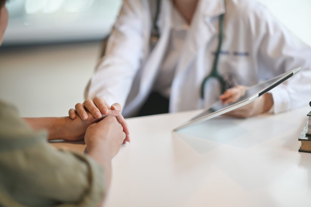 Compassionate doctor holding a patient's hand during a ketamine therapy consultation at Better Health Whole Wellness Center.